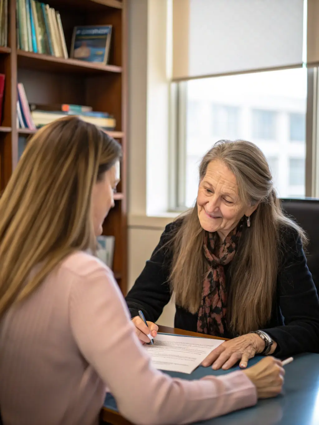 A young woman being mentored by an experienced professional in a bright, modern office setting, discussing career goals and strategies.
